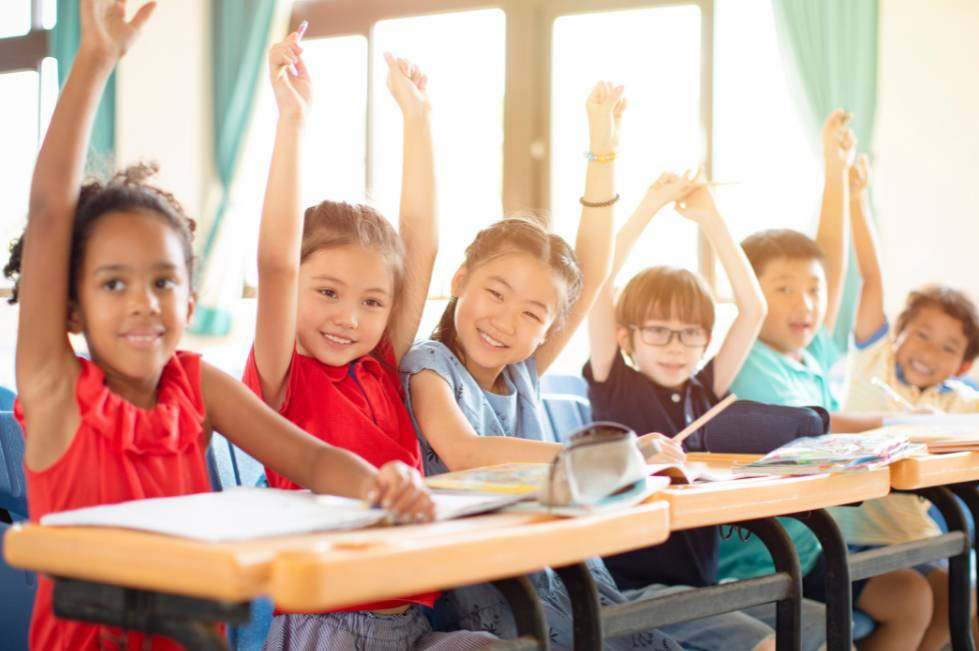 Children raising hands in a classroom